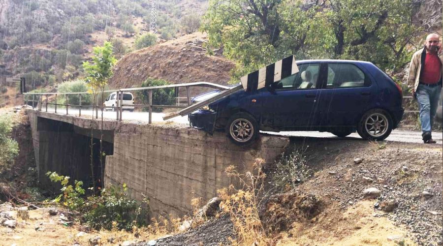 Otomobil kayganlaşan yolda köprüde asılı kaldı