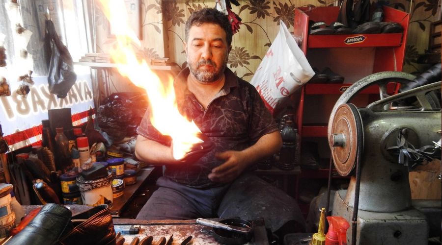 Ayakkabıları 45 derecede ateşle yakarak boyuyor